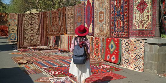 Armenia Yerevan Woman Viewing Carpets At Vernissage Market Downtown
