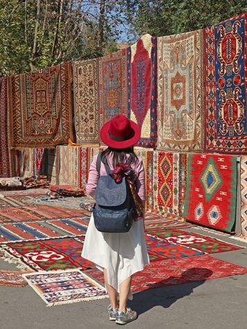 Armenia Yerevan Woman Viewing Carpets At Vernissage Market Downtown