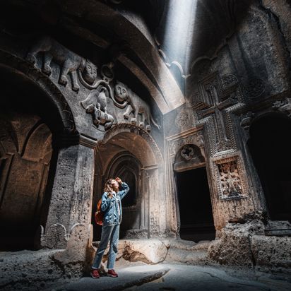Armenian Geghard Monastery Woman Explores Ancient Bas Reliefs On Walls